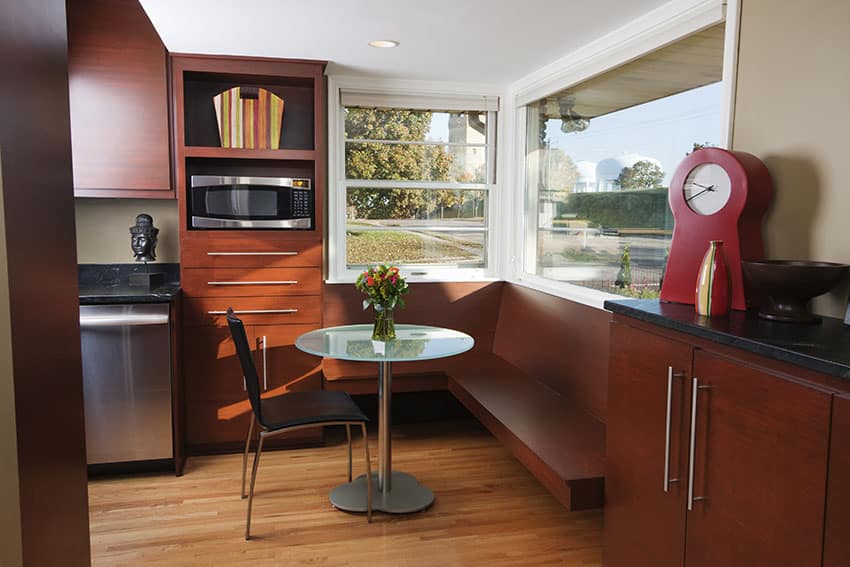 Breakfast nook with reddish brown cabinet glass windows