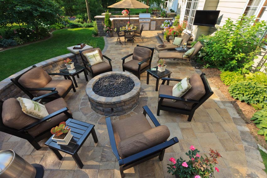 Backyard fire pit surrounded by chairs travertine tiles