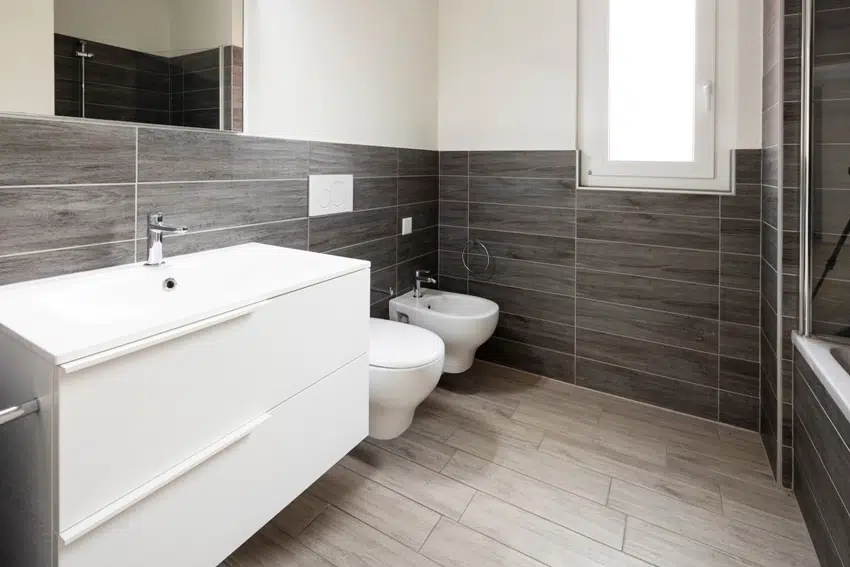 A bathroom with elegant minimalist halfway brown tile walls