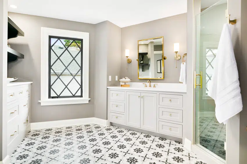 Bathroom with gray walls drawers patterned tile floor glass door window