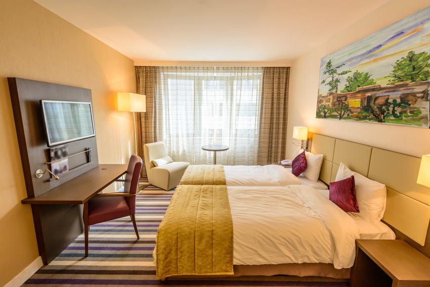 Bedroom with brown curtain yellow walls television rug shelf