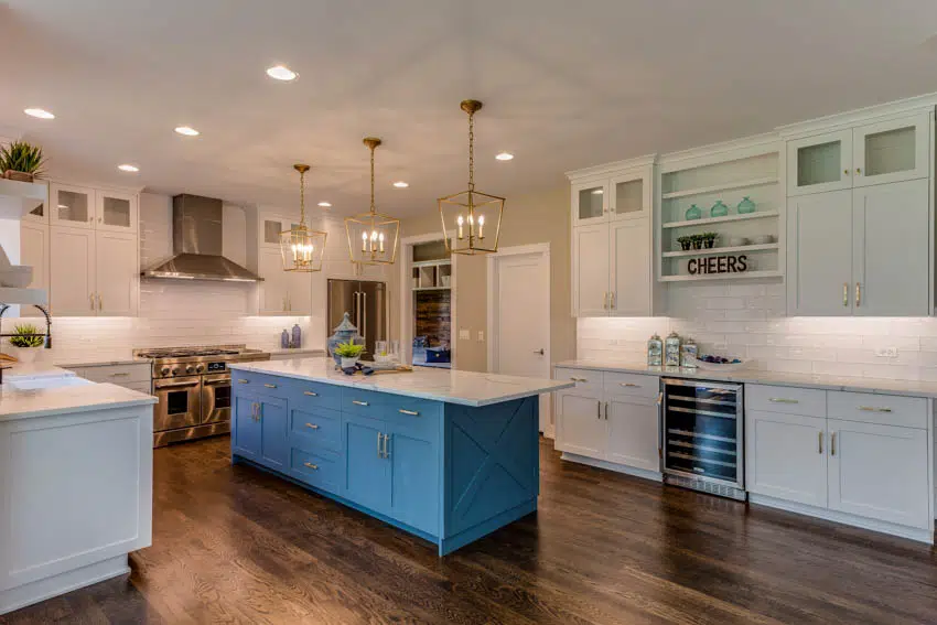 Blue kitchen with center vase island decor, and wood flooring 