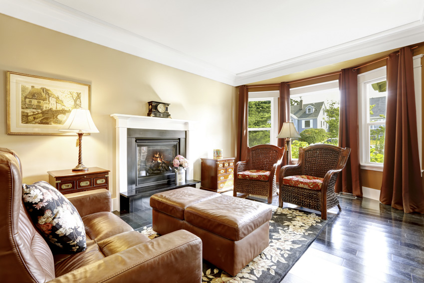 Classic living room with yellow walls rust colored curtains sofa leather chairs