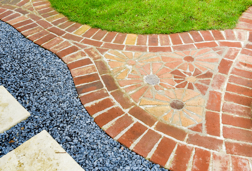 Complex brick paver pattern with gravel walkway