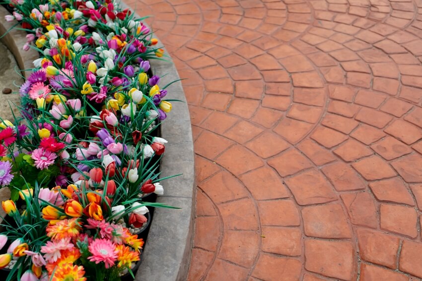 Concrete paver look with colorful flowers on the side