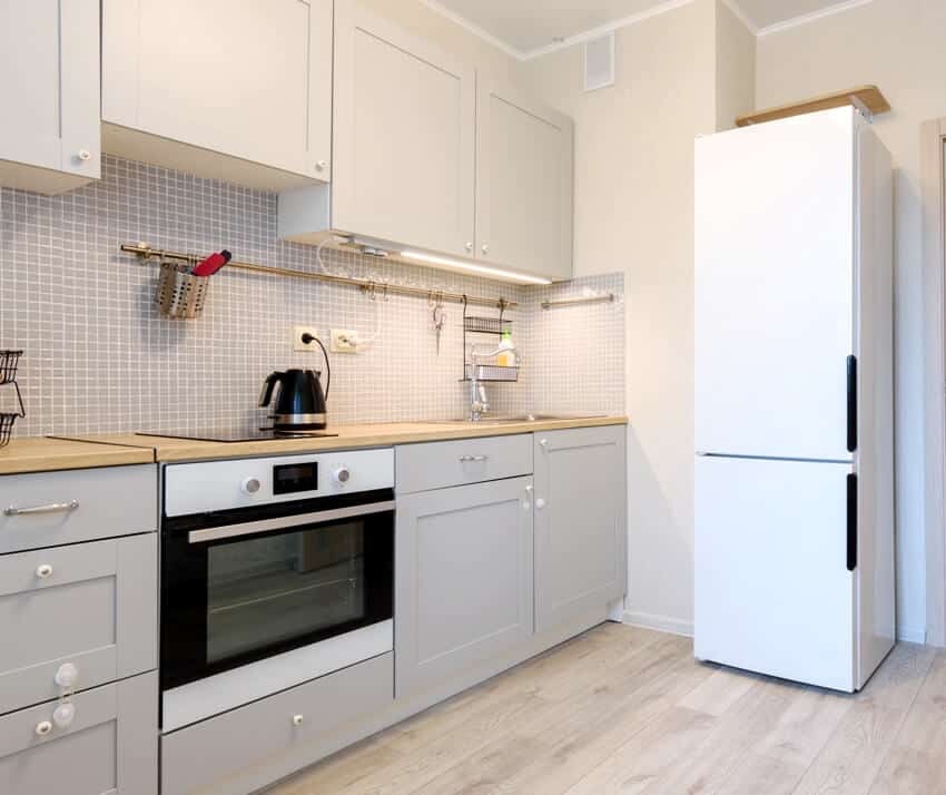 Gray interior of a small cozy kitchen with white appliances