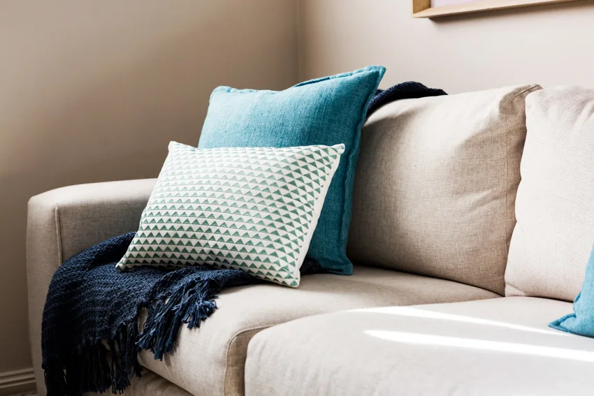 Blue throw pillows and earth toned sofa