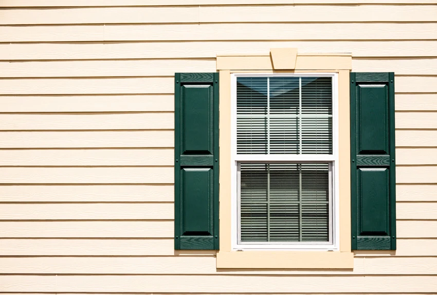 Green raised panel shutters and cream exterior siding