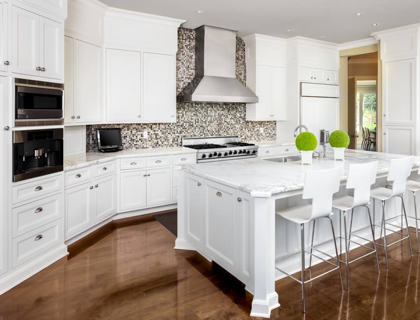 Kitchen with island with sink, cabinets, oven and range 