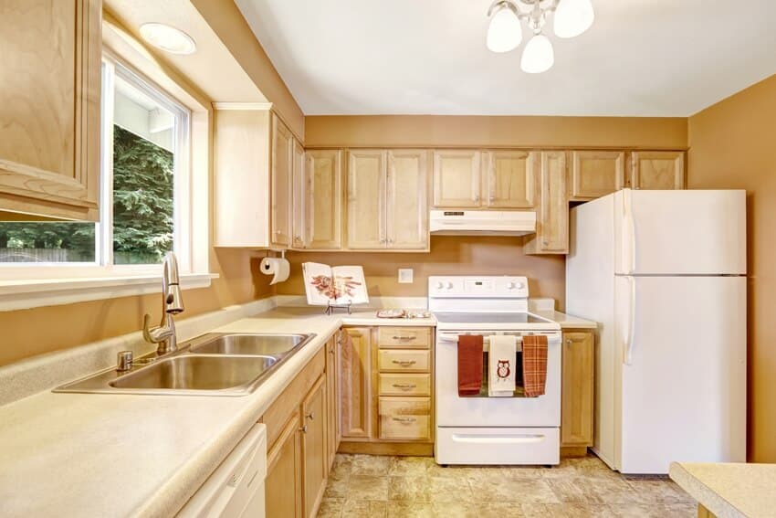 Kitchen with wooden cabinets in light tones with white appliances