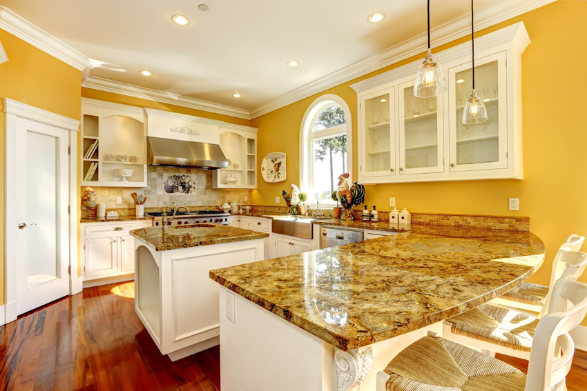 Kitchen with yellow walls, marble countertop and wood flooring