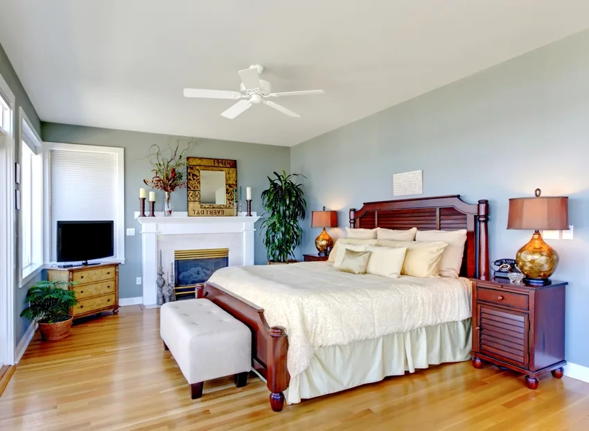 Large bedroom with fireplace cherry wood furniture and green walls