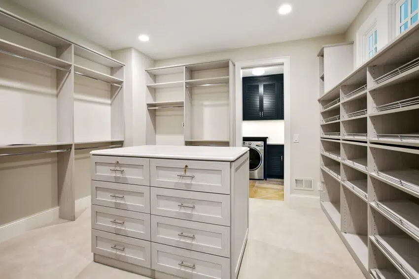 Light gray interior of a spacious closet with an island dresser