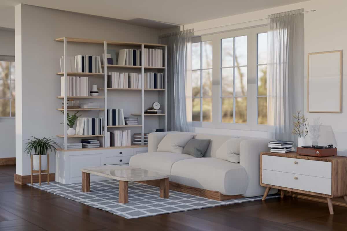 living space with open back bookcase sofa and window