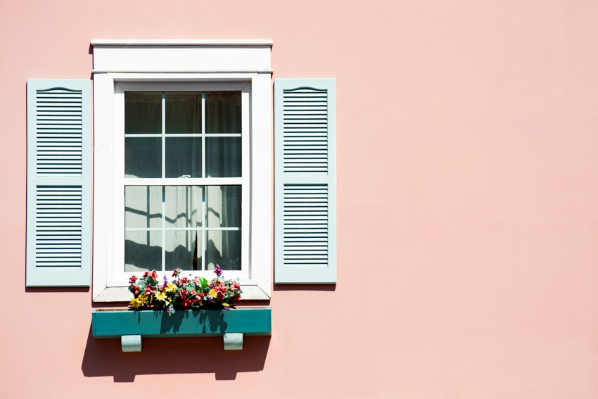 Louvered shutters on pastel pink wall