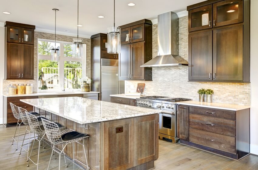 Kitchen with large granite island and natural brown wood cabinets 