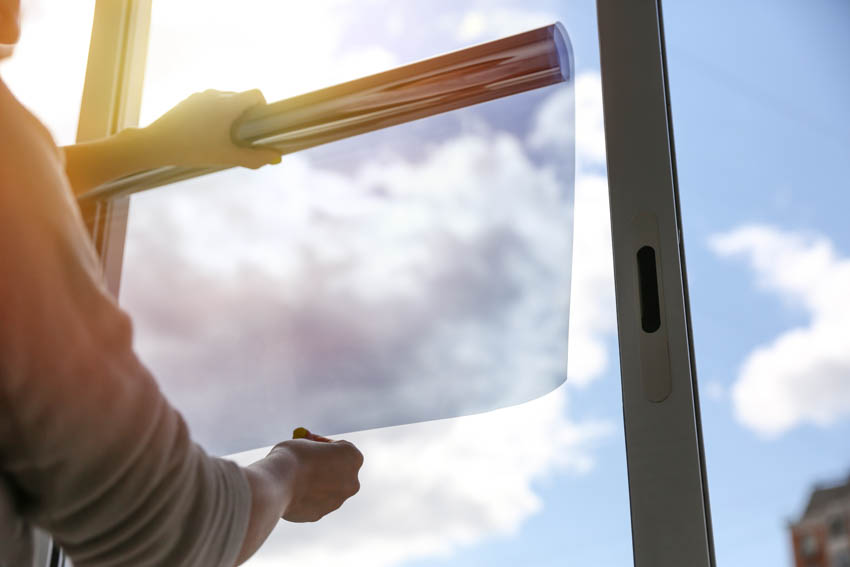 Man applying tint on window