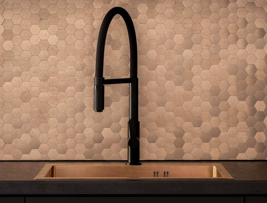 Mosaic tile pattern backsplash black countertop faucet