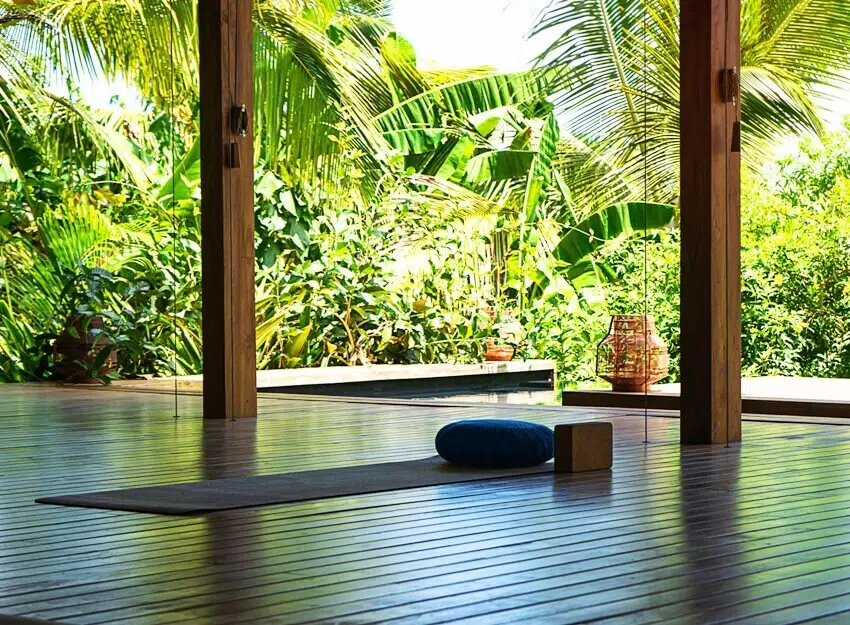 An open tropical yoga studio place with view outside to the beautiful garden with palm trees