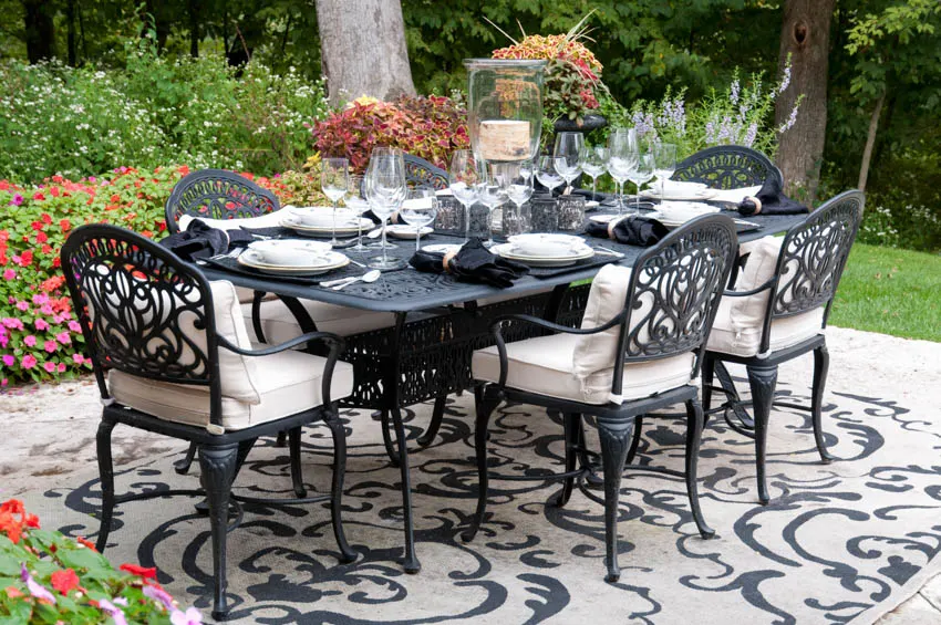 Outdoor table and powdercoated chairs on rug backyard