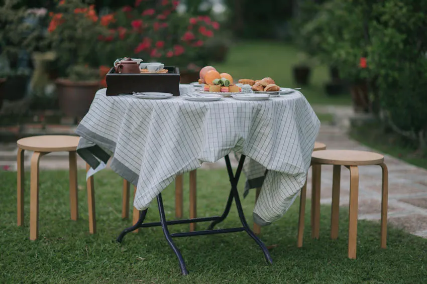 Outdoor table with tablecloth wood stools