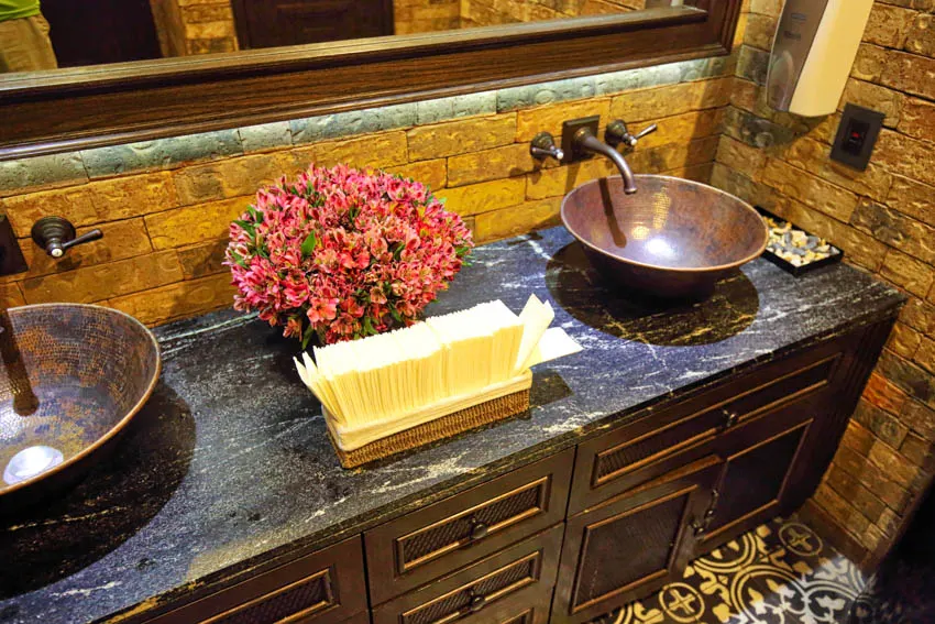Pair of sinks made of copper on top of wooden drawers