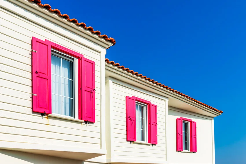Traditional exterior shutters in bright pink