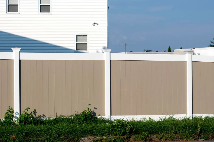 White and beige vinyl fence outside a residential home