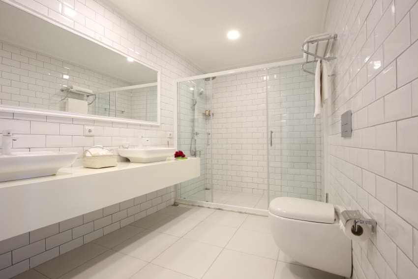 White tile bathroom with big mirror