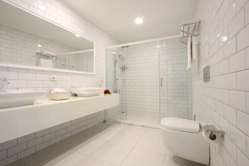 White tile bathroom interior with big mirror