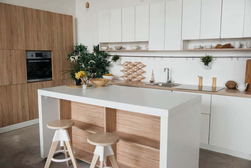 White kitchen island with centerpiece wood cabinet drawers