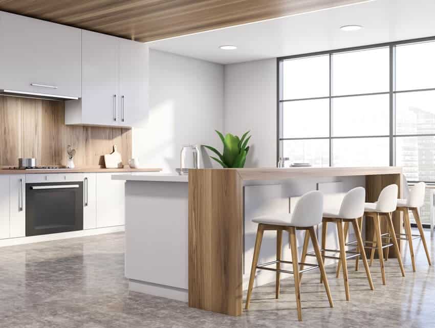 White modern kitchen with island chairs and windows