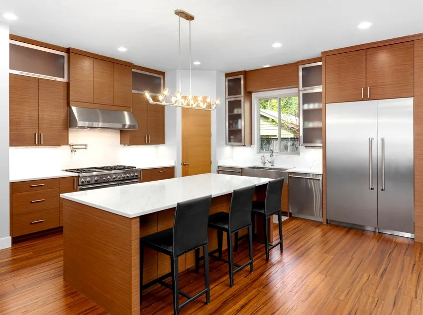 Wooden kitchen interior with stainless steel appliances kitchen island with black chairs and marble countertop