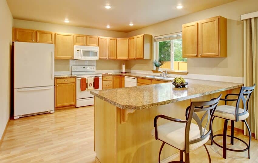 Yellow light tone kitchen with wood cabinets and white appliances