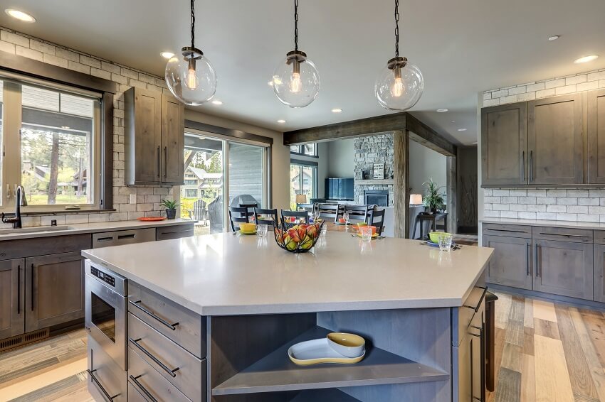 Kitchen interior with grey tone of brown muted natural tones with light hardwood and rustic modern island with colorful plates