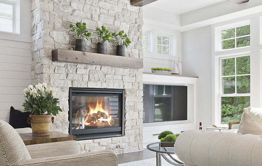 Fireplace with wood mantel, brick surround and indoor plants
