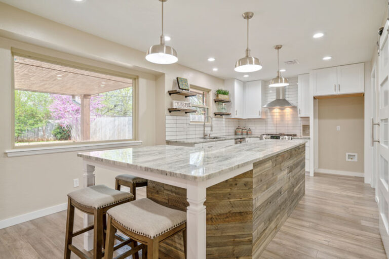 Beautiful Kitchen With Center Island Hanging Lights Wood Flooring Windows Ss 768x512 