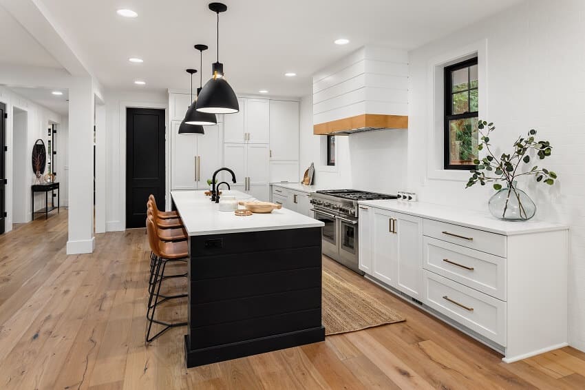 Beautiful white kitchen with dark accents in new farmhouse style luxury home