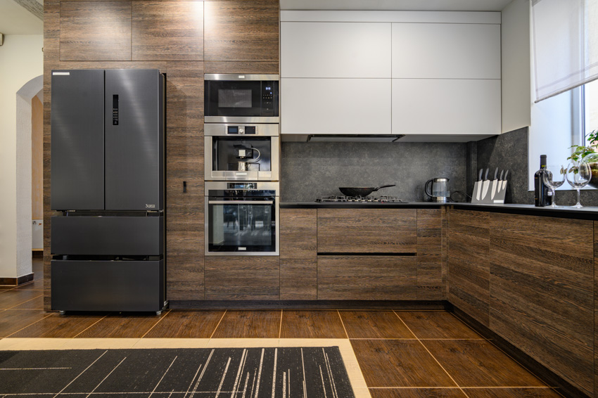 Black stainless steel appliances, wood and white kitchen cabinets 