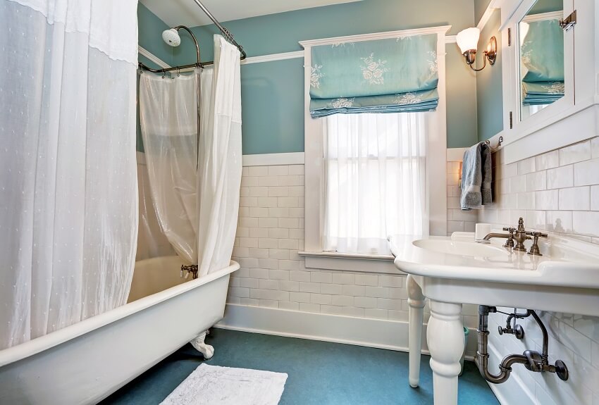 Blue bathroom interior with white tile trim wall white sink and bath tub