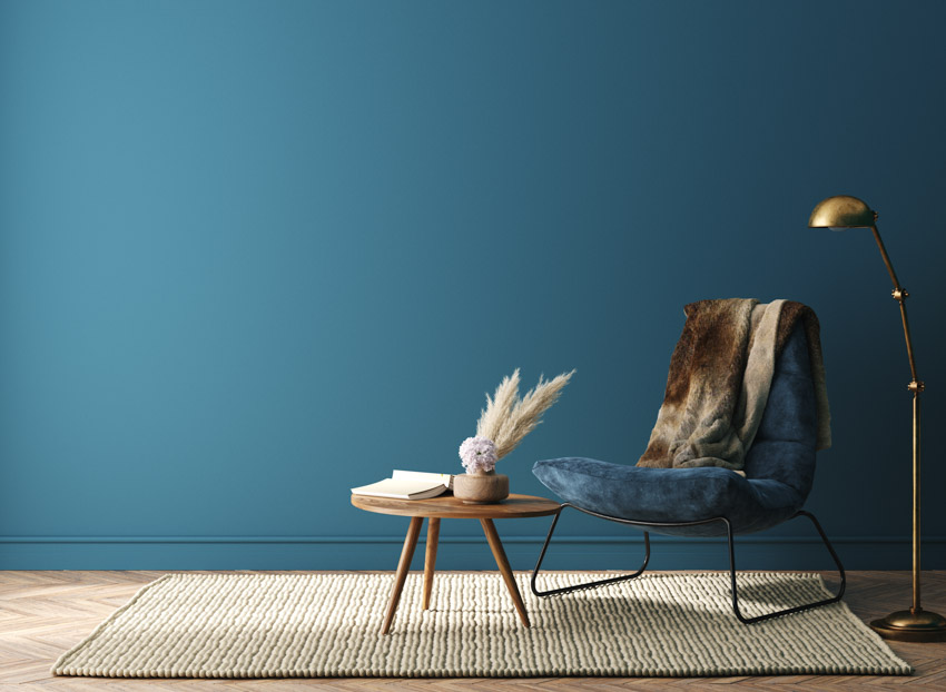 Blue green wall baseboard coffeetable chair lamp rug
