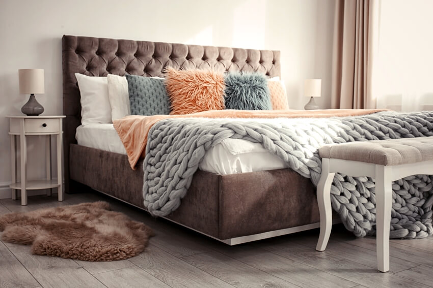 Brown luxury bed with tufted headboard in a bedroom
