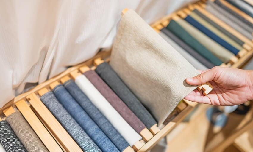 Choosing the roll of fabric with earth tone cone and textile