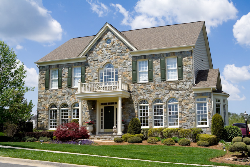 Classic house exterior stone siding pitched roof glass windows