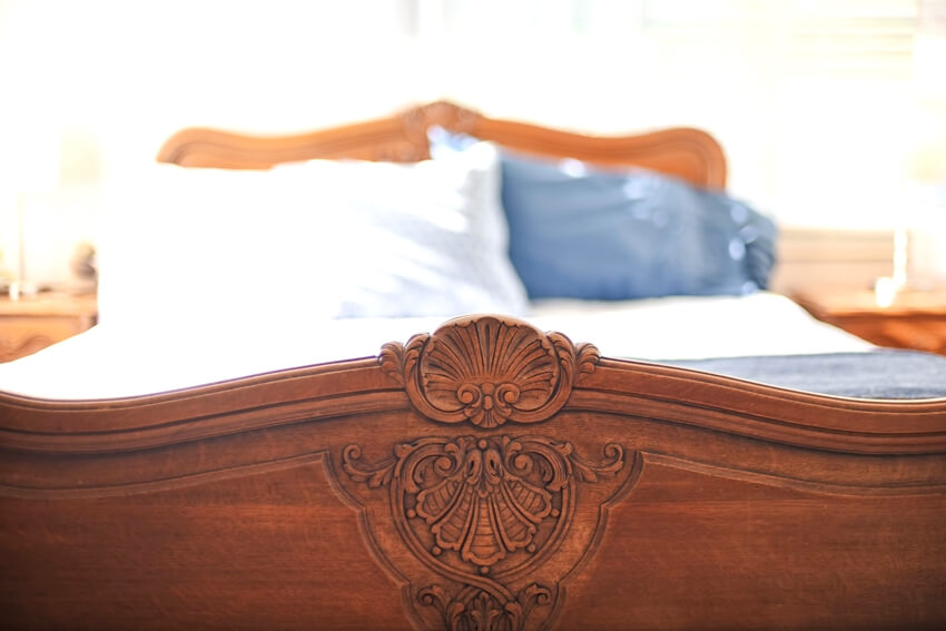 Closeup of wood carving detail on antique oak footboard