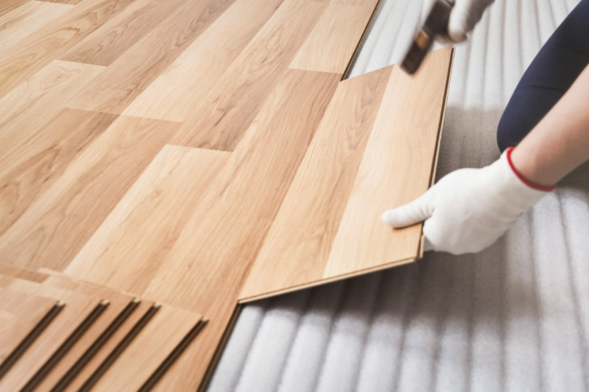 Contractor installing prefinished hardwood floor panels