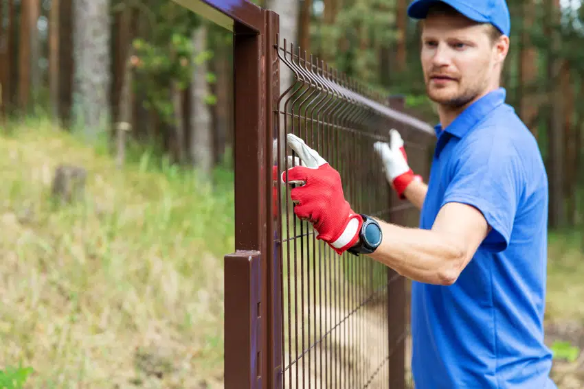 A contractor installing steel fence