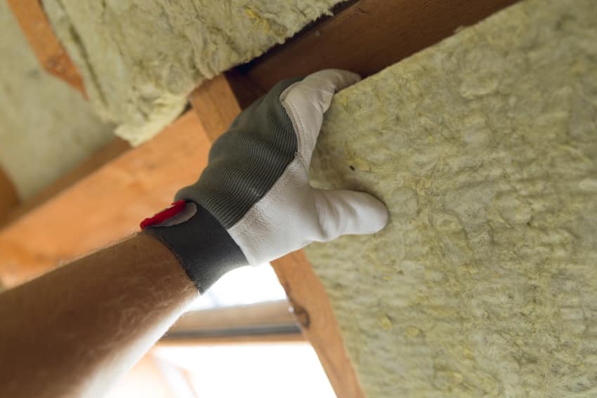 Contractor removing insulation from attic
