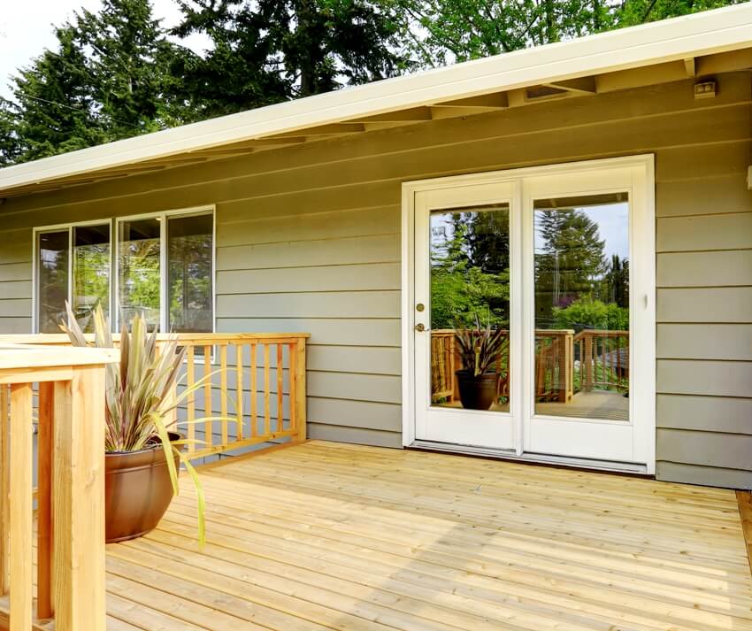 Countryside house with wooden walkout deck tinted doors and patio area 