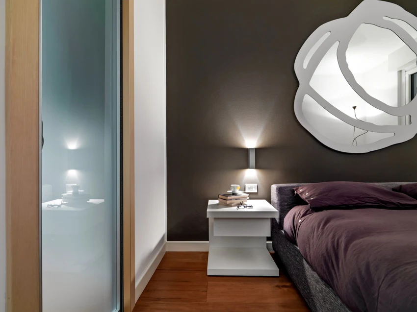 Custom mirror hanging above bed glass divider table lamp
